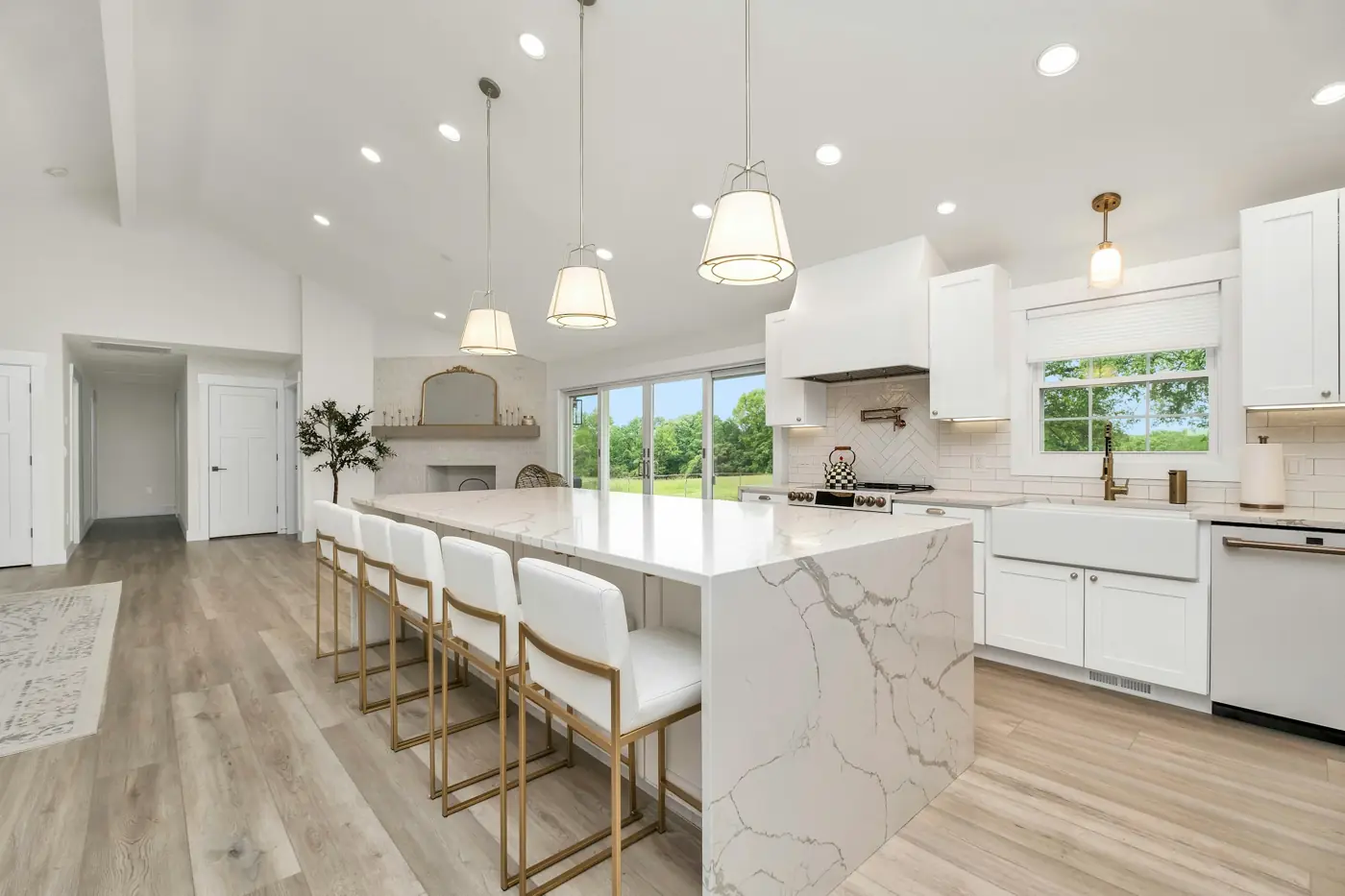 Clean white kitchen with a marble island